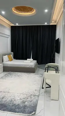 a bedroom with two beds and a table and a chair at Boutique Studio Elegant Stay in Arjan Dubai in Dubai