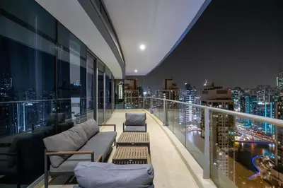 a balcony with couches and a city skyline at night at GuestReady - 2BR l Stunning Marina Views in Dubai