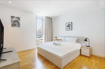 a white bedroom with a bed and a large window at Livbnb- 3BR with Maid's Room with Full Ain Dubai View in Dubai