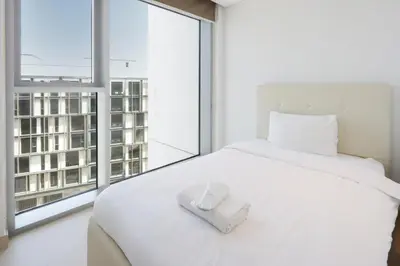 a bedroom with a white bed with a large window at Livbnb- 3BR with Maid's Room with Full Ain Dubai View in Dubai