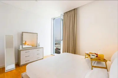 a bedroom with a white bed and a mirror at Livbnb- 3BR with Maid's Room with Full Ain Dubai View in Dubai
