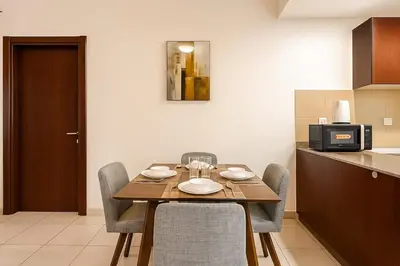 a dining room table and chairs in a kitchen at Convenient Location in JVC Bright 1BR with Balcony in Dubai