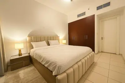 a bedroom with a large bed and a cabinet at Convenient Location in JVC Bright 1BR with Balcony in Dubai