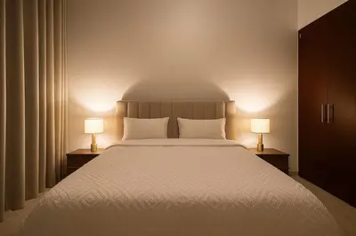 a bedroom with a large bed with two lamps at Convenient Location in JVC Bright 1BR with Balcony in Dubai