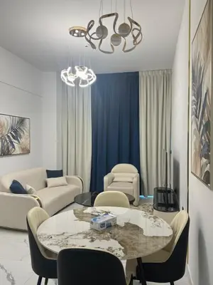 a living room with a table with chairs and a couch at Luxury 2BR in Opal by Danube Private pool in Dubai