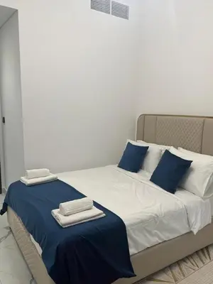 a bed with blue and white sheets and towels on it at Luxury 2BR in Opal by Danube Private pool in Dubai