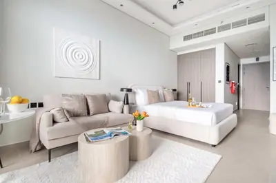 a white living room with a bed and a couch at Frank Porter - Al Serh Residences 11 in Dubai