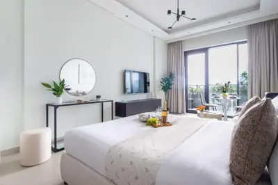 a white bedroom with a large bed and a mirror at Frank Porter - Al Serh Residences 11 in Dubai