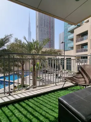 a balcony with a view of a pool and palm trees at Studio at Burj Views L246 in Dubai