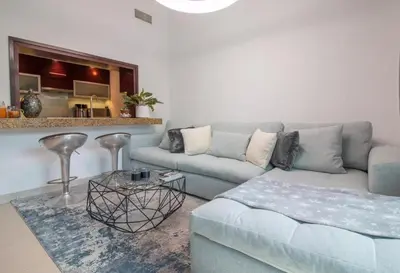 a living room with a blue couch and a table at Studio at Burj Views L246 in Dubai