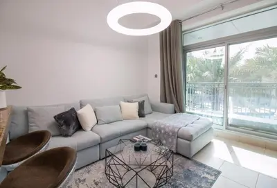 a living room with a couch and a large window at Studio at Burj Views L246 in Dubai