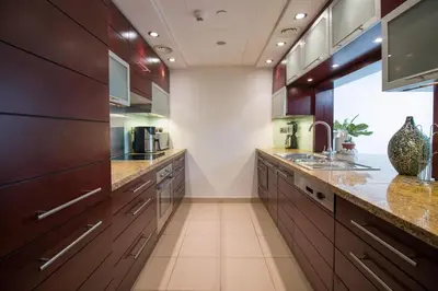 a large kitchen with wooden cabinets and granite counter tops at Studio at Burj Views L246 in Dubai
