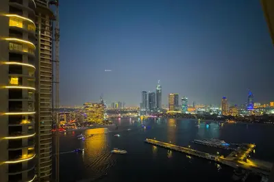a view of a city at night from a building at Lush Apartment - Private Beach Emaar - Beachfront in Dubai