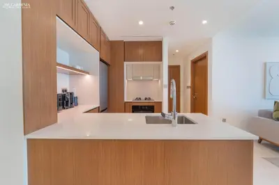 a kitchen with a white counter top and wooden cabinets at Lush Apartment - Private Beach Emaar - Beachfront in Dubai