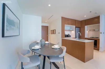 a kitchen and dining room with a table and chairs at Lush Apartment - Private Beach Emaar - Beachfront in Dubai