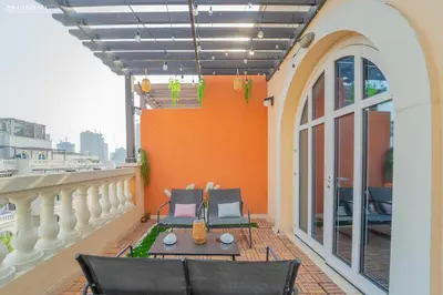 a balcony with two chairs and a table on a building at Peaceful Apartment - Cozy Interiors - 1BR in JVC in Dubai