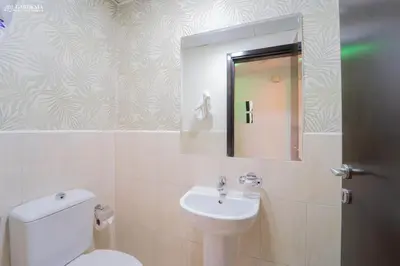 a bathroom with a toilet and a sink and a mirror at Peaceful Apartment - Cozy Interiors - 1BR in JVC in Dubai