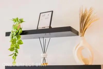 a black shelf with a vase and a plant at 1BR Elite Residence4304 in Dubai