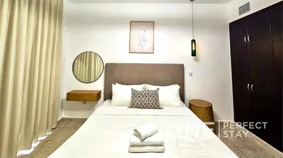 a bedroom with a large white bed and a mirror at 1BR Diamond Views 403A in Dubai