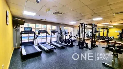 a gym with several treadmills and tread machines at 1BR Diamond Views 403A in Dubai