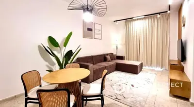 a living room with a couch and a table and chairs at 1BR Diamond Views 403A in Dubai