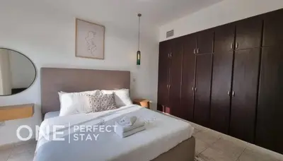 a bedroom with a large bed and a mirror at 1BR Diamond Views 403A in Dubai