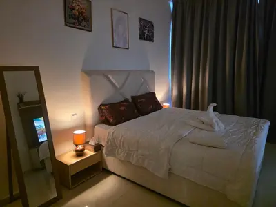 a bedroom with a white bed and a mirror at Dragon Golden Apartment 003 in Dubai
