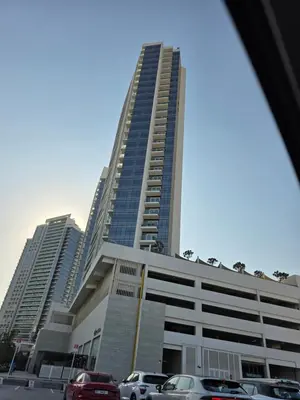 a tall building with cars parked in front of it at Dragon Golden Apartment 003 in Dubai