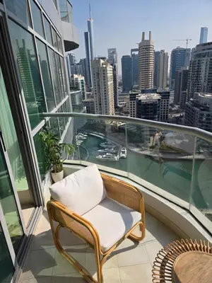 a chair on a balcony with a view of the city at Chic waterfront 1 bedroom apartment, walk to beach, promenade, metro in Dubai