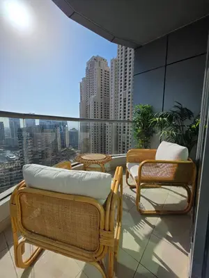 a balcony with chairs and a couch and a view of a city at Chic waterfront 1 bedroom apartment, walk to beach, promenade, metro in Dubai