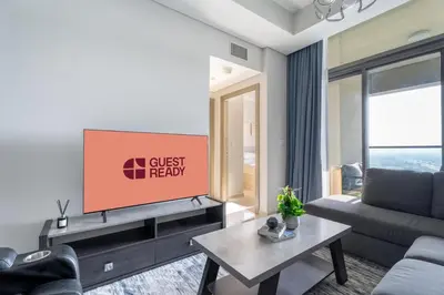 a living room with a couch and a flat screen tv at GuestReady - 2BR l City Chic in the Sky in Dubai