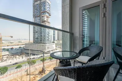 a balcony with chairs and a table and a view of a city at GuestReady - Lux Apt Downtown | Near Dubai Mall in Dubai