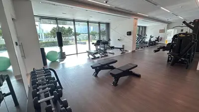 a gym with exercise equipment and chairs in a room at Downtown with Direct Access Dubai Mall & Burj Khalifa in Dubai