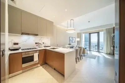 a kitchen with a counter and a dining room at Maison dOpera by NAMUVE - Boulevard Views in Dubai