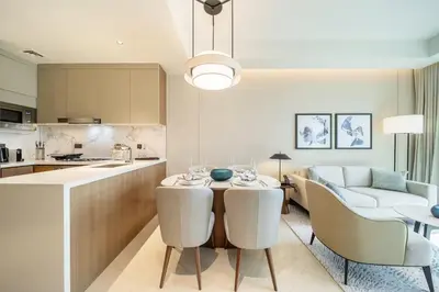 a kitchen and living room with a table and chairs at Maison dOpera by NAMUVE - Boulevard Views in Dubai