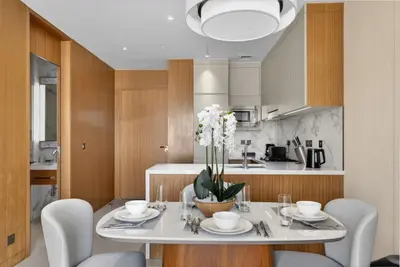 a dining room with a table and chairs and a kitchen at Address Residences Dubai Opera - Boulevard Views 1 & 2 Bedroom Apartment 5 minute walk to Burj Khalifa & Dubai Mall by NAMUVE in Dubai