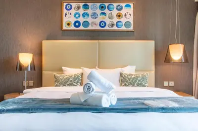 a bedroom with a large bed with two lamps at 2BR - DAMAC Towers by Paramount - Business Bay in Dubai