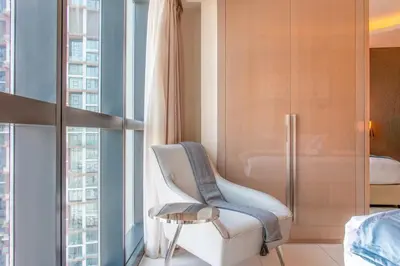 a bedroom with a white chair and a table at 2BR - DAMAC Towers by Paramount - Business Bay in Dubai