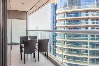a table and chairs in a room with a large window at Old Hollywood Glamour by Namuve - Damac Paramount in Dubai