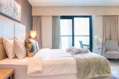 a bedroom with a large white bed with a window at Old Hollywood Glamour by Namuve - Damac Paramount in Dubai