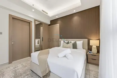 a bedroom with a white bed and a wooden wall at Minutes from Dubai Marina with Easy Access to Sheikh Mohammed Bin Zayed Road - Cloud Tower A, Jumeirah Village Triangle by Deluxe Holiday Homes in Dubai