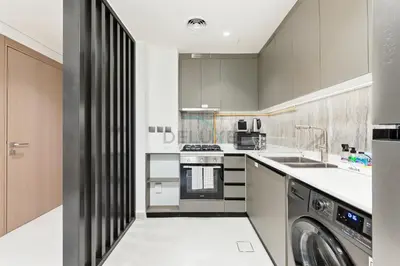 a kitchen with a sink and a dishwasher at Minutes from Dubai Marina with Easy Access to Sheikh Mohammed Bin Zayed Road - Cloud Tower A, Jumeirah Village Triangle by Deluxe Holiday Homes in Dubai