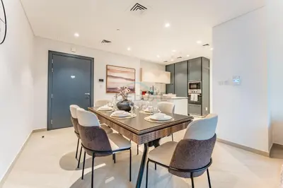 a dining room with a table and chairs at Furnished Balcony with Creek Views, Near Ras Al Khor Wildlife Sanctuary and Downtown Dubai - Wilton Park Residences 1, Sobha Hartland by Deluxe Holiday Homes in Dubai