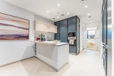 a kitchen with black cabinets and a white counter top at Furnished Balcony with Creek Views, Near Ras Al Khor Wildlife Sanctuary and Downtown Dubai - Wilton Park Residences 1, Sobha Hartland by Deluxe Holiday Homes in Dubai
