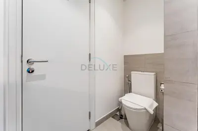 a white toilet in a bathroom with a glass door at Furnished Balcony with Creek Views, Near Ras Al Khor Wildlife Sanctuary and Downtown Dubai - Wilton Park Residences 1, Sobha Hartland by Deluxe Holiday Homes in Dubai