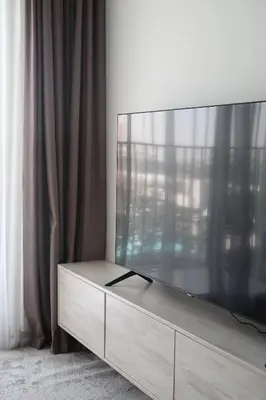 a large flat screen tv sitting on top of a dresser at Designed 2BR in Socio Dubai Hills in Dubai