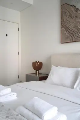 a bedroom with a white bed with towels on it at Designed 2BR in Socio Dubai Hills in Dubai