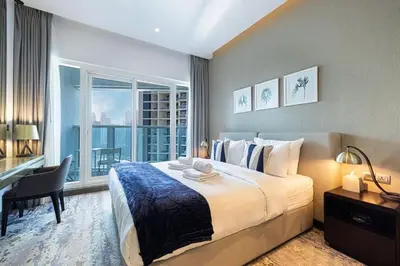 a bedroom with a bed and a desk and a window at Contemporary Studio in Business Bay - Burj Khalifa View - Gym & Pool in Dubai