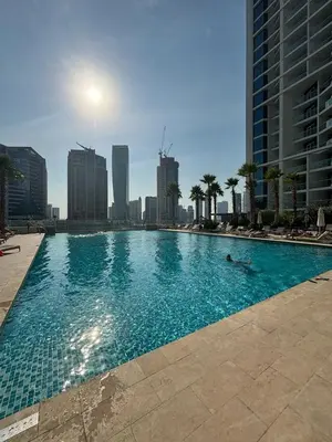 a person laying in a swimming pool in a city at Contemporary Studio in Business Bay - Burj Khalifa View - Gym & Pool in Dubai