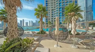 a view of a resort with palm trees and a pool at Contemporary Studio in Business Bay - Burj Khalifa View - Gym & Pool in Dubai